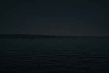 Дальний берег залива с редкими огнями и темной водой