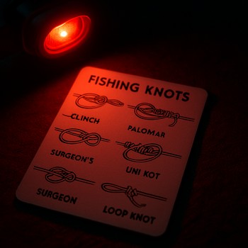 Доска с примерами узлов для ночной рыбалки под тёплым светом фонаря