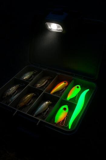 Открытая коробка с приманками в свете налобного фонаря