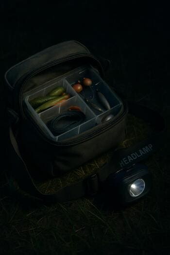 Сумка со снастями и фонарём на ночной траве